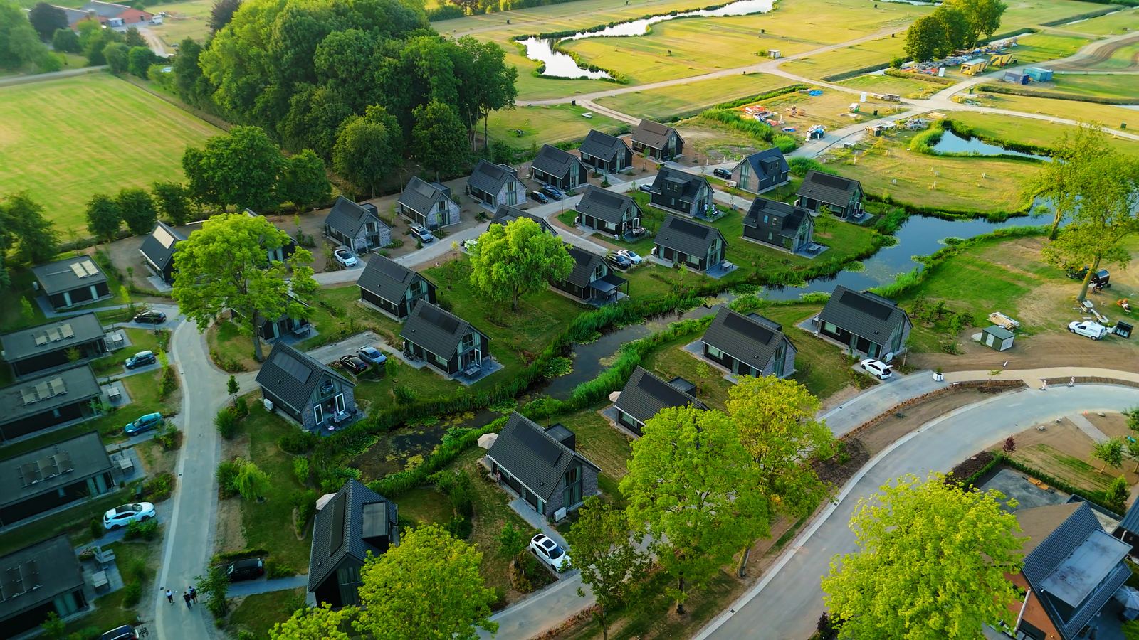 Luchtfoto van een Recraparcs vakantiepark met vrijstaande recreatiewoningen langs het water
